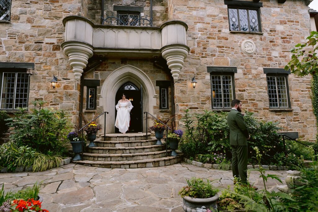 A person walking down a small staircase towards their partner for their first look at their wedding 