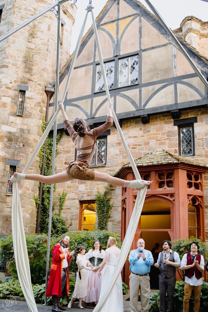 An acrobat performing in front of a small crowd of wedding guests 