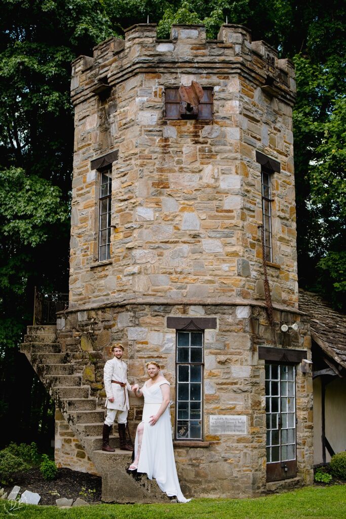 A couple standing on a stone staircase attached to a windmill 