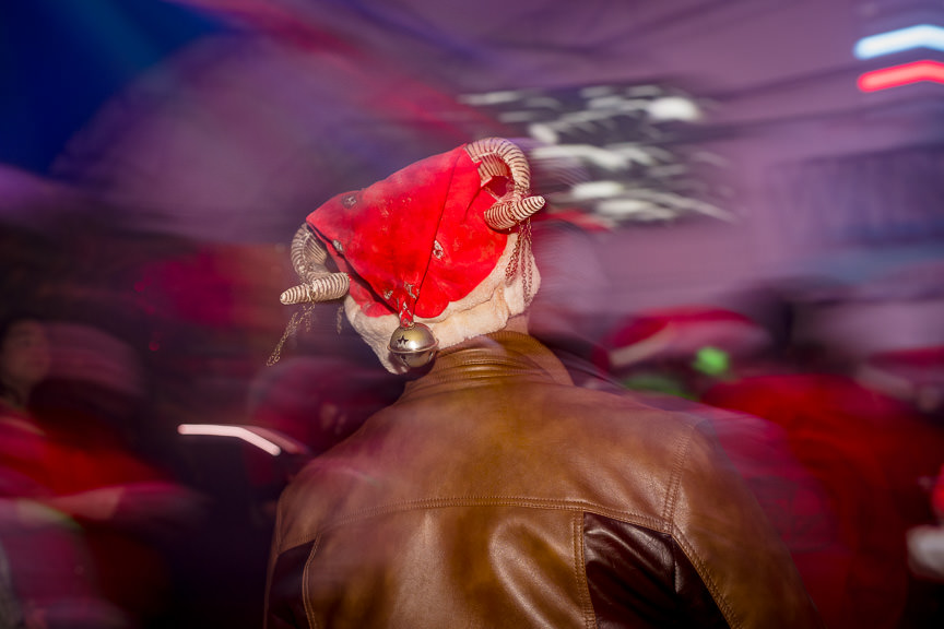 Blurry dance floor photo of Santa hat with horns.