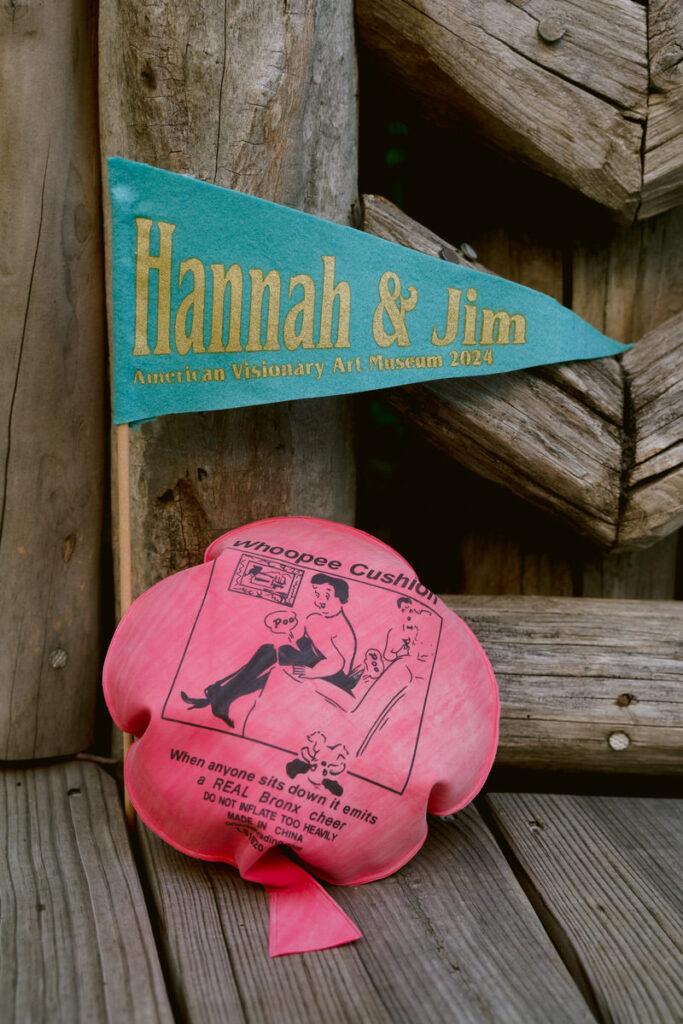 A whoopie cushion sitting next to a flag that reads "Hannah & Jim" 