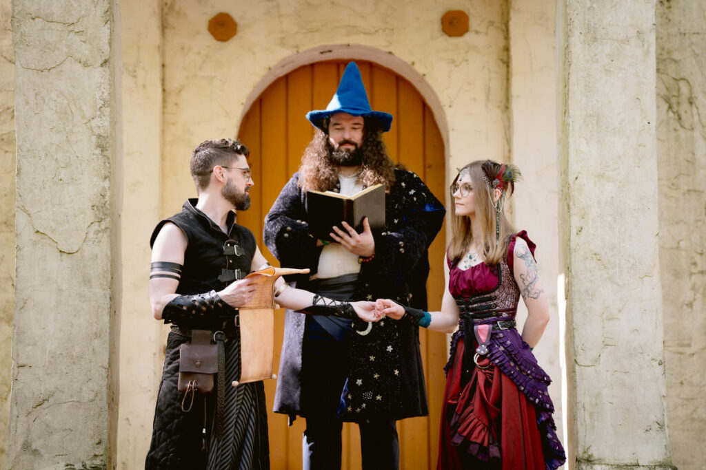 A couple holding hands as they say their vows at their Renaissance Festival wedding 