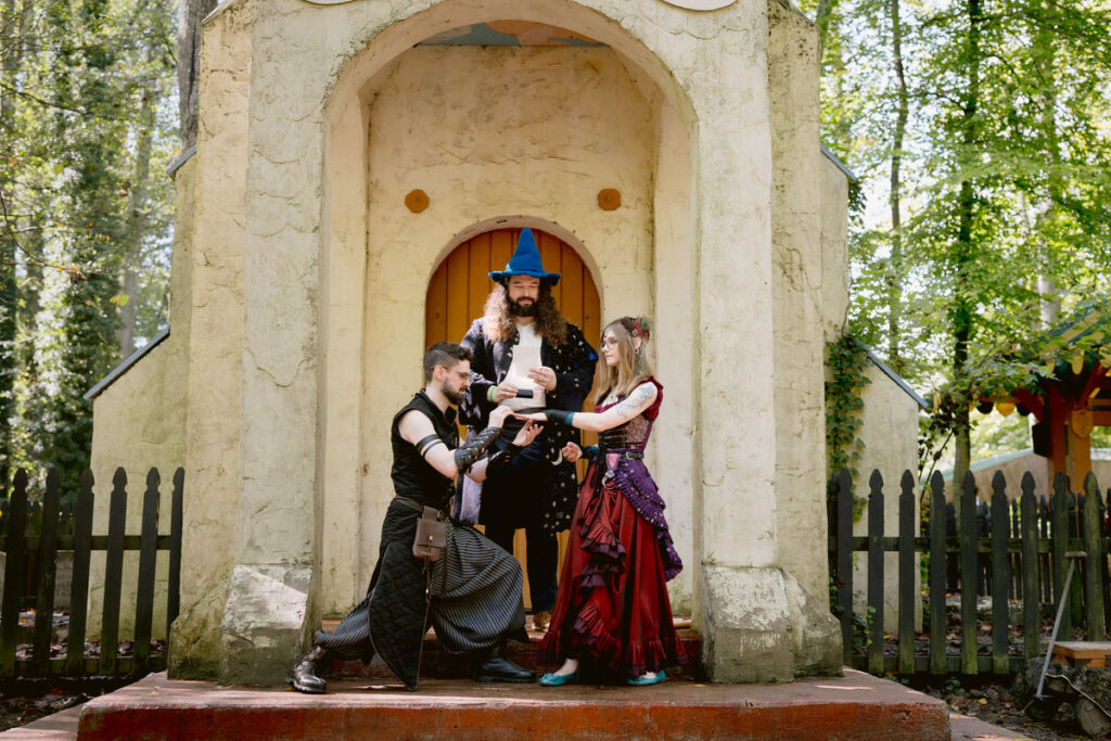 A person kneeling down as they put a ring on their partner's hand during their wedding ceremony 
