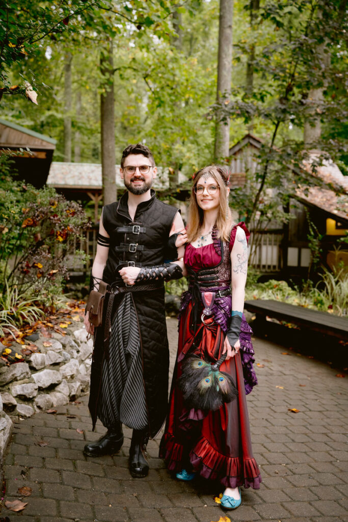 A newlywed couple in medieval clothes smiling 
