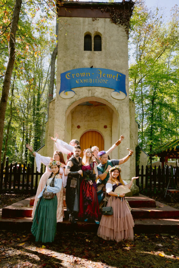 Wedding guests celebrating with a newlywed couple as they are all dressed up in Renaissance Festival costumes 
