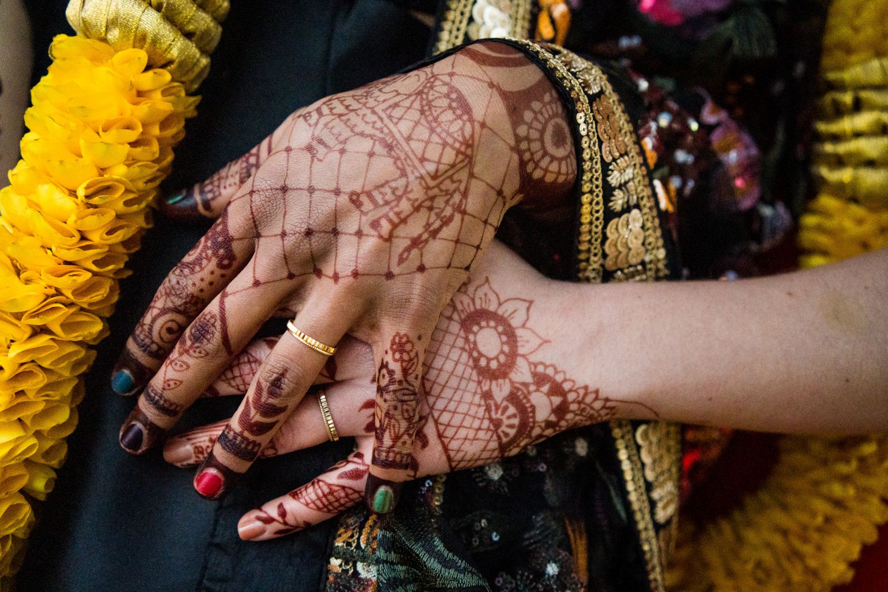 two different hands both with henna on them 